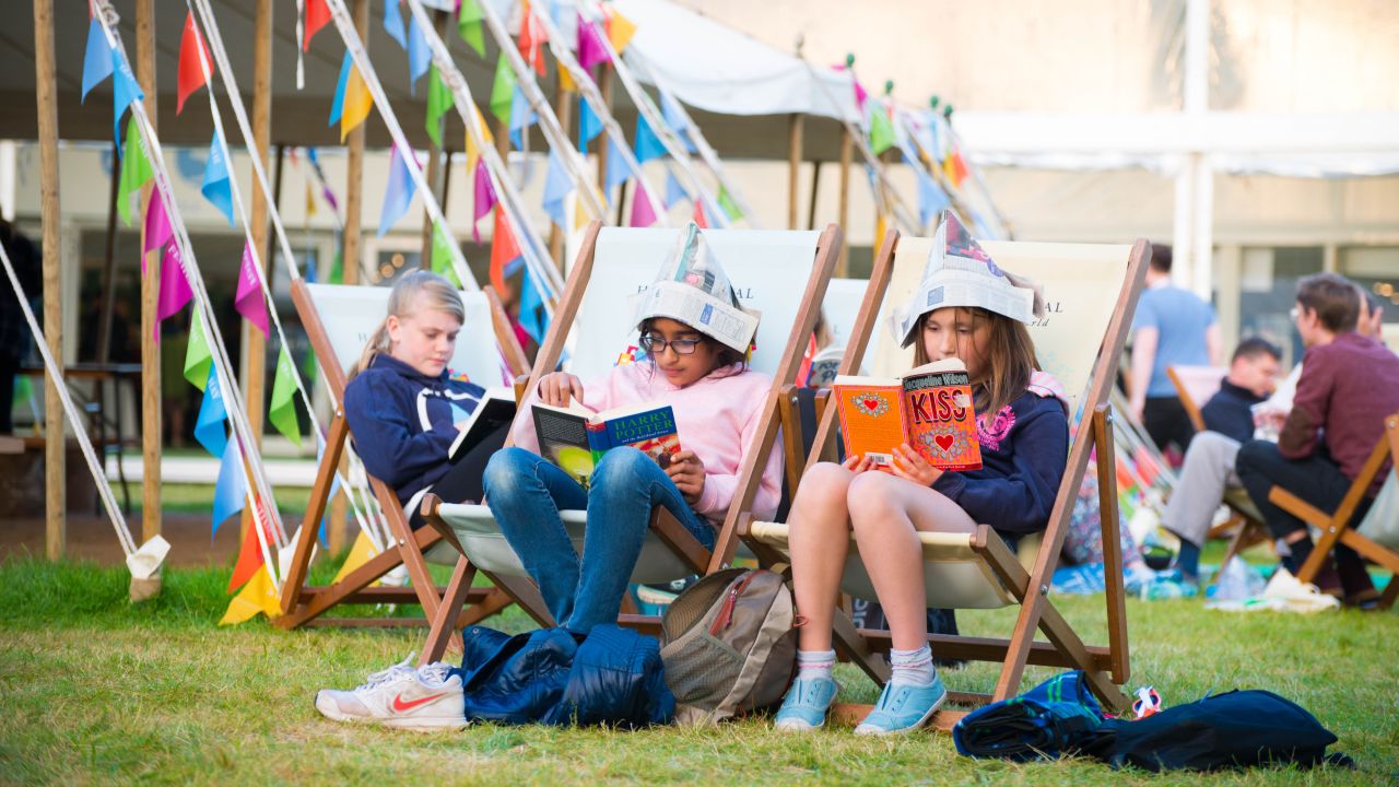 Girls reading in deckchairs at Hay